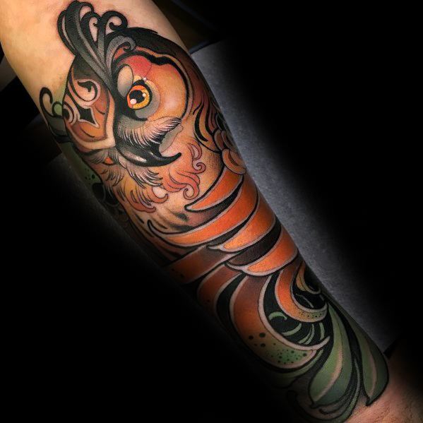 Neo-traditional owl tattoo with bold lines, vibrant orange hues, and intricate feather details, creating a dynamic and artistic forearm design.