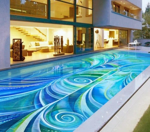 Stunning pool with a vibrant, artistic mosaic tile design featuring swirling blue and green patterns.