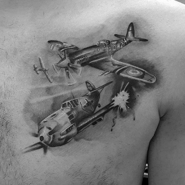 Realistic black and grey chest tattoo depicting a dramatic WWII dogfight, featuring detailed fighter planes, motion effects, and an explosion.