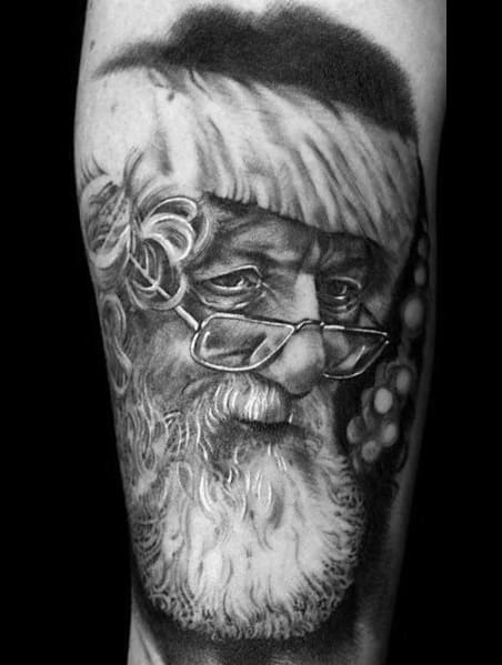 Black and grey realistic Santa Claus tattoo featuring detailed shading, expressive eyes, and glasses resting on his nose for a classic holiday look.