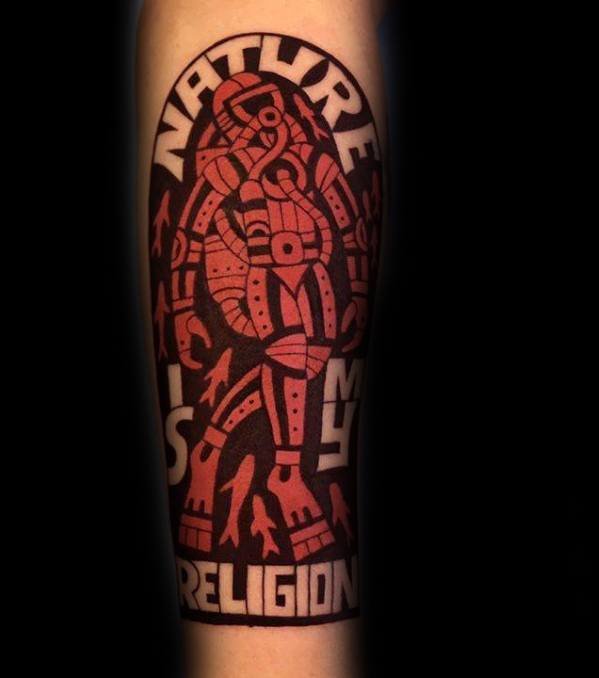 Bold scuba diver tattoo in tribal style with red and black tones, featuring the phrase “Nature is my religion.”