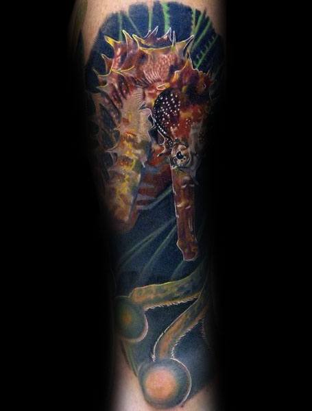 Realistic seahorse tattoo on forearm, featuring rich colors, intricate textures, and an underwater background for a lifelike, immersive design.