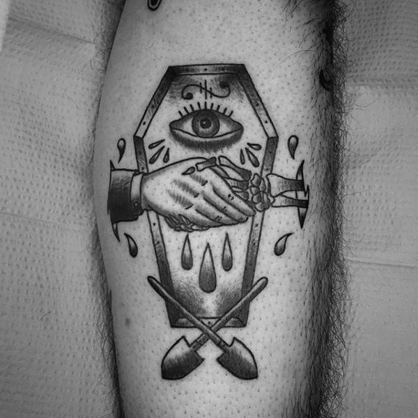 Black and grey tattoo featuring a coffin with an eye, two hands shaking, crossed shovels, and dripping tears, symbolizing secrecy and burial.