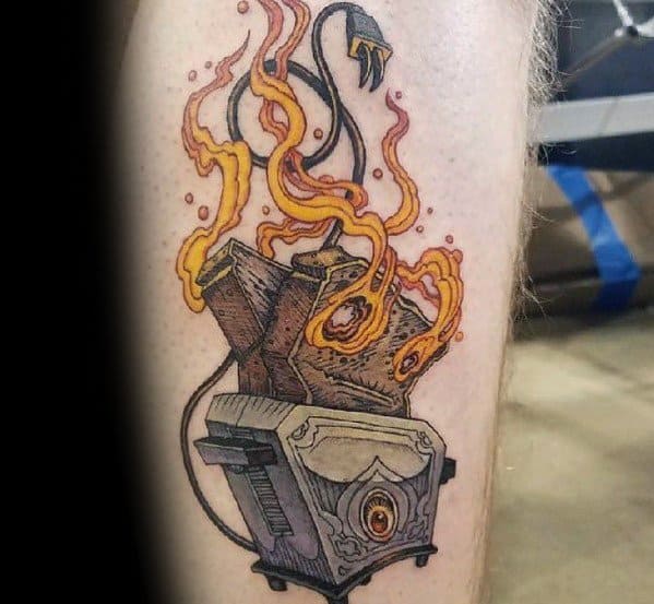 Detailed burning toaster tattoo with flames engulfing toast and a frayed power cord, combining realism and a vintage aesthetic with bold colors.