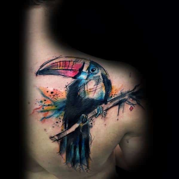 Watercolor-style toucan tattoo on the upper back with bold brushstroke lines and splashes of blue, orange, and pink for an artistic flair.