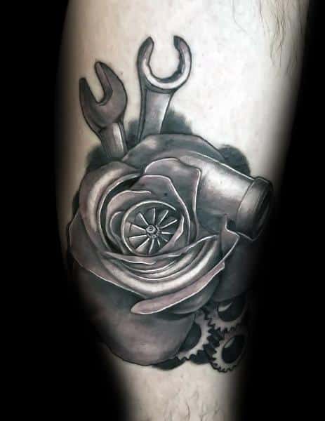 Realistic black and gray tattoo featuring a turbocharger integrated into a rose with wrenches and gears, symbolizing a fusion of mechanics and beauty.