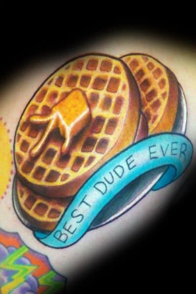 Stacked waffle tattoo with melted butter and a blue banner reading "Best Dude Ever," combining a love for breakfast with a fun tribute theme.