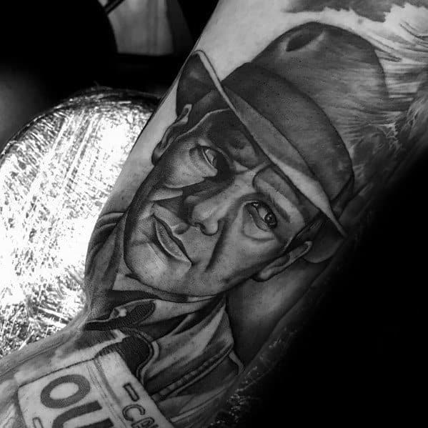 Realistic black and gray Indiana Jones tattoo capturing his determined expression, iconic fedora, and detailed shading for depth.
