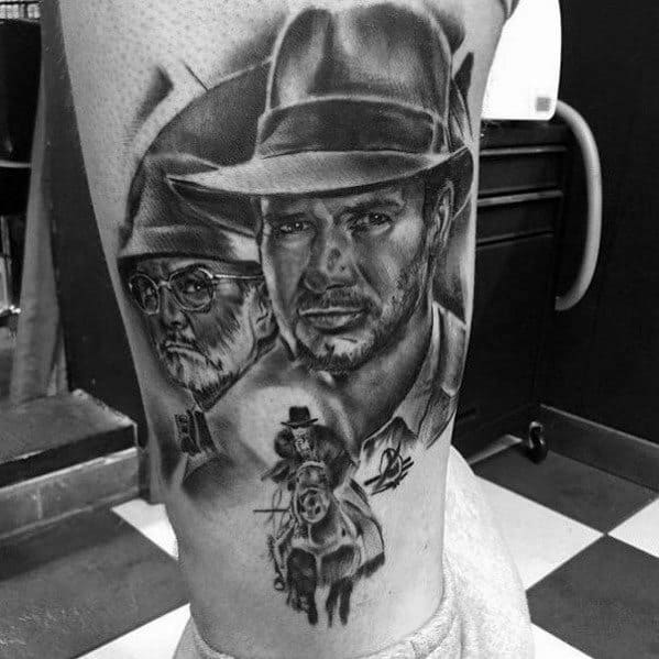 Black and gray Indiana Jones tattoo featuring Indy, his father Henry Jones Sr., and an action scene on horseback, detailed with shading.