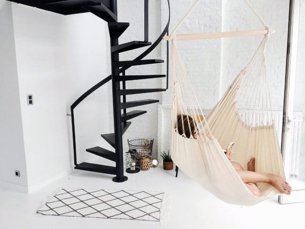 Blue hammock in a rustic cabin with panoramic windows and a stunning mountain view.