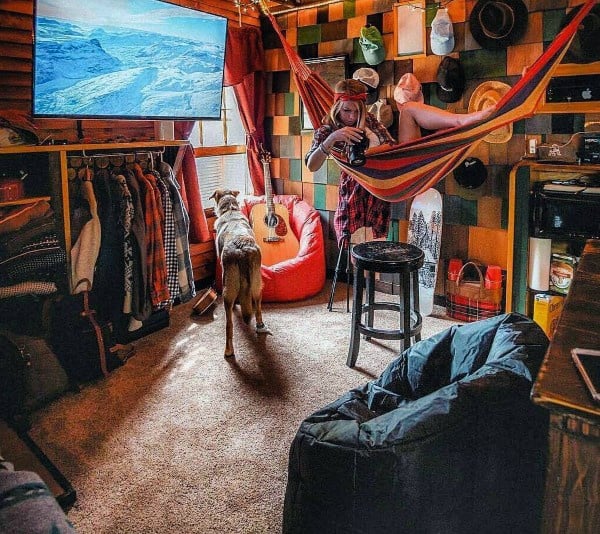 Colorful hammock in a cozy, eclectic room with a guitar, dog, and vibrant decor accents.