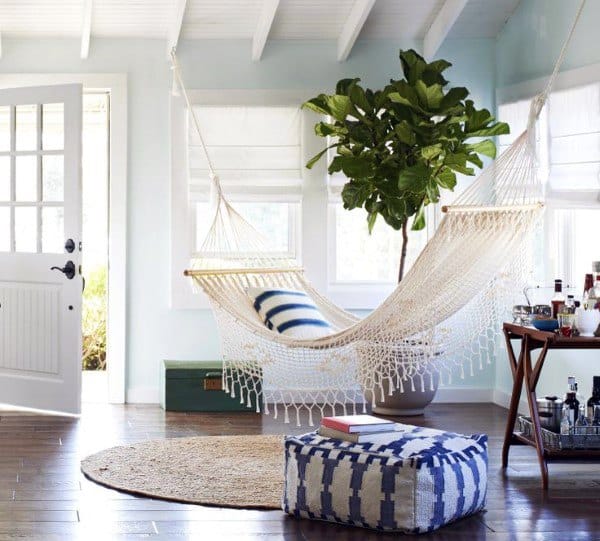 White hammock in a bright living room with a fiddle leaf fig and cozy decor accents.