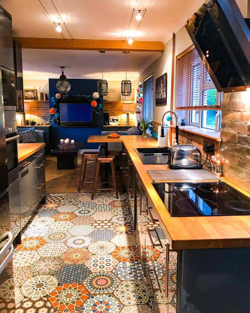 open-plan kitchen living room wood countertops stools wall mounted tv pattern floor tiles