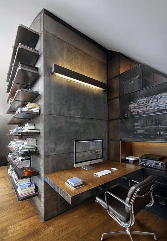 Industrial home office with concrete walls, wooden desk, and metal shelving.