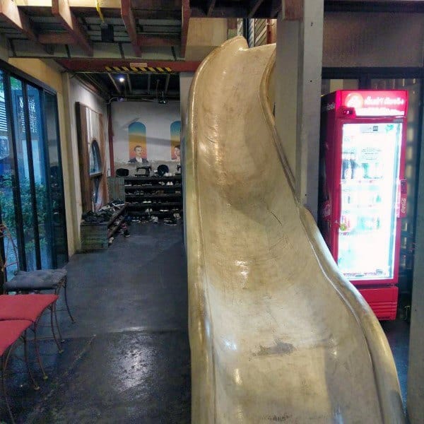 Indoor slide brings you to a restaurant with a red fridge and stunning wall art backdrop