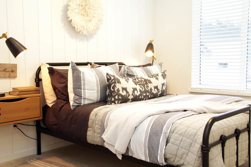 white bedroom with black cast iron bed frame