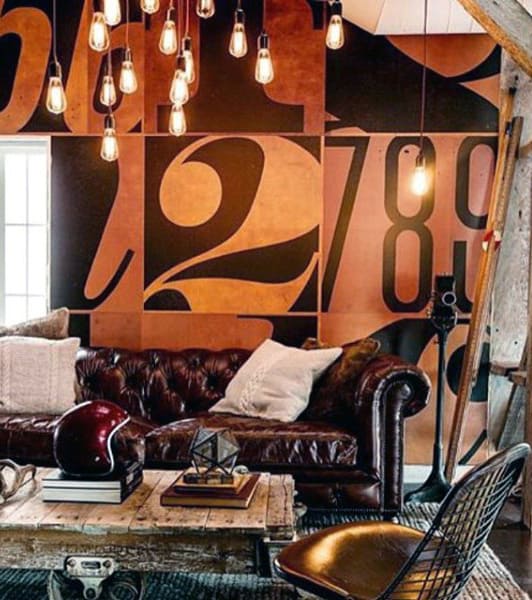 Industrial-style living room with leather sofa, number-patterned wall, and vintage decor accents.