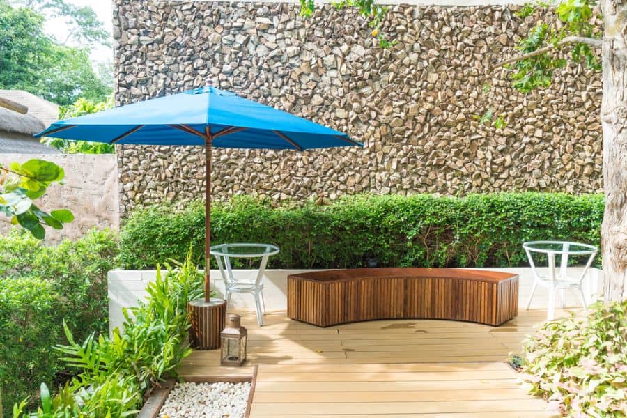 small wood deck patio with bench seating and umbrella