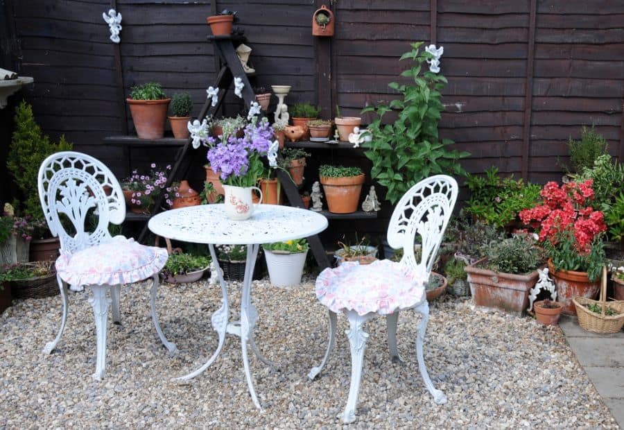 gravel patio with ornate white table and chairs