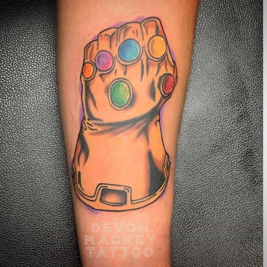 Bold Infinity Gauntlet tattoo featuring vibrant Infinity Stones, outlined in black with subtle shading