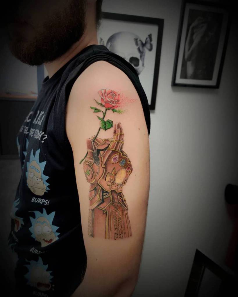 Creative Infinity Gauntlet tattoo with detailed shading, featuring Thanos’ gauntlet delicately holding a blooming red rose