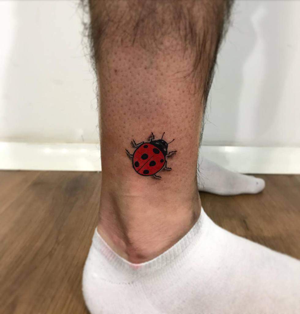Simple and bold ladybug tattoo on the ankle, featuring a vibrant red shell with black spots for a classic and eye-catching design.