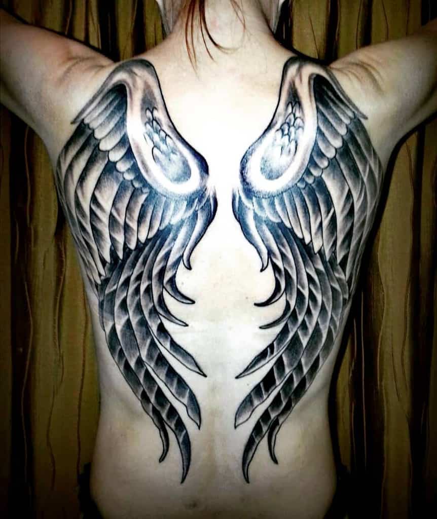Large black and grey angel wings tattoo featuring intricate feather details for a bold, realistic effect.