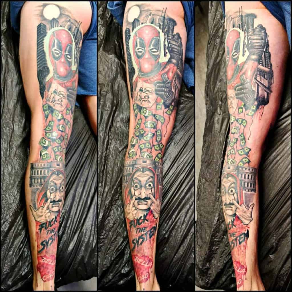 Colorful tattoo leg sleeve featuring Deadpool with a rebellious attitude, surrounded by dollar bills and imagery from Money Heist, along with the phrase 'FUCK THE SYSTEM,' 