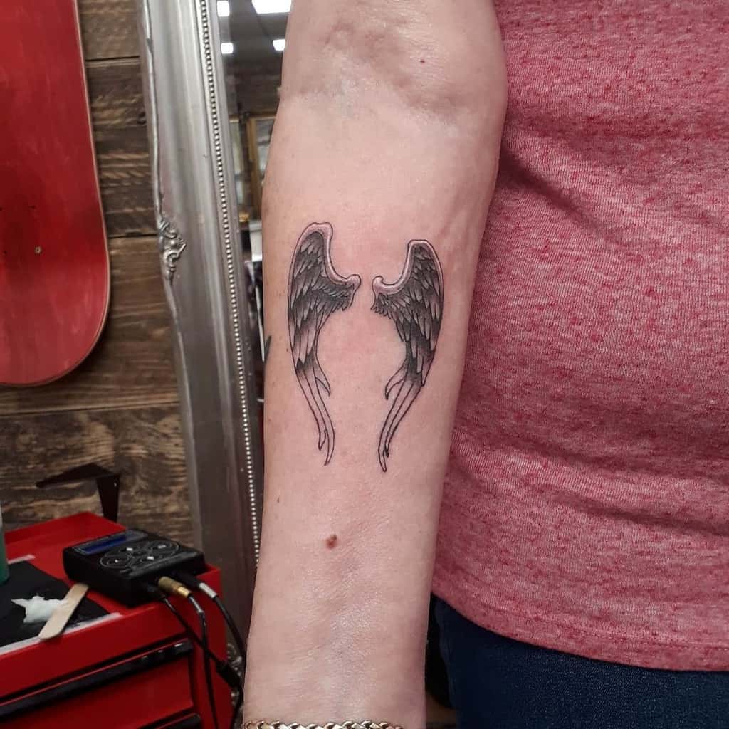 Tattoo of black and white realistic angel wings