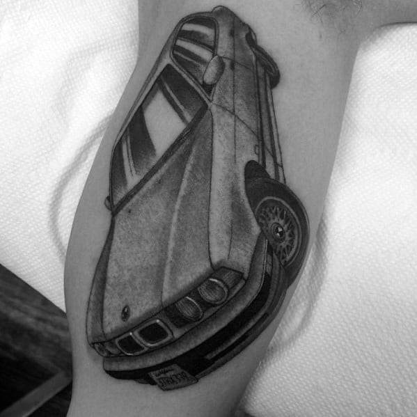 Realistic BMW E34 tattoo on arm, featuring bold shading and a dynamic angled perspective for a striking automotive design.