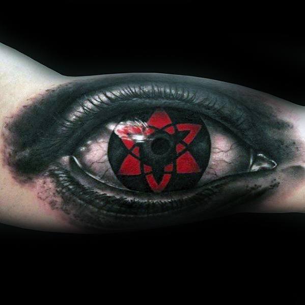 Tattoo of a realistic eye with a red and black star design in the iris, evoking a Naruto-inspired style