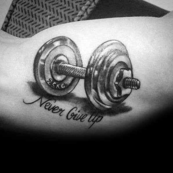 Realistic dumbbell tattoo with "Never Give Up" script, symbolizing strength and determination in fitness and personal growth.