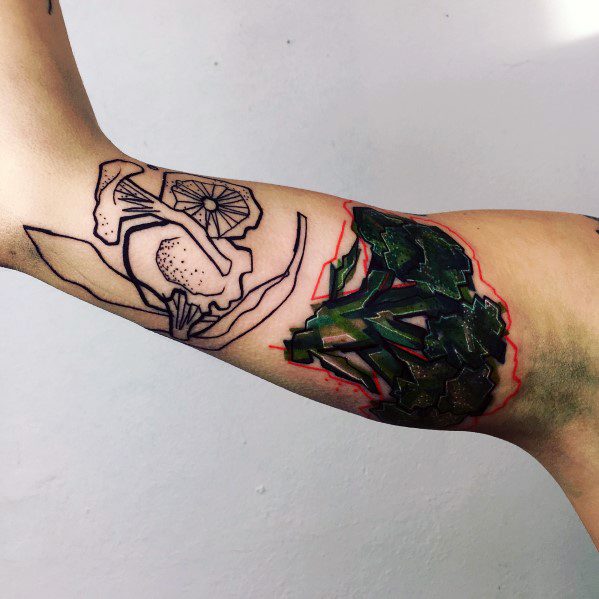 Unique broccoli tattoo on the inner arm, blending bold black line art with a hyper-realistic torn skin effect, creating a striking contrast.