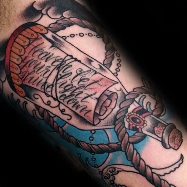 Tattoo of cursive writing in a bottle tied with rope on an arm