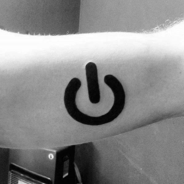 Bold black power symbol tattoo on the inner arm, featuring a clean and minimalistic design.
