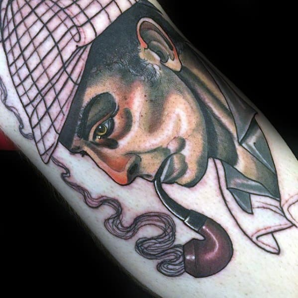 Tattoo of Sherlock Holmes in a checkered hat, pipe in hand, with smoke curling around his face