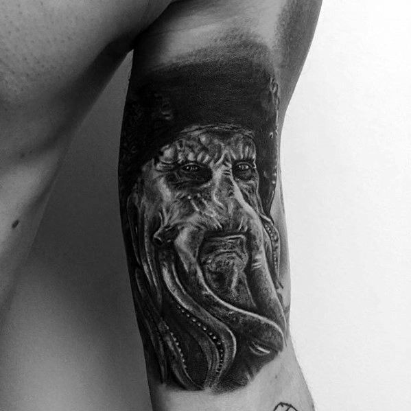 Davy Jones' mythical sea creature tattoo in black and white wraps around the arm