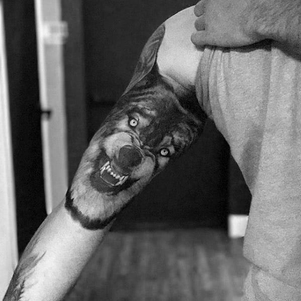 Inner Arm Bicep Realistic Sick Wolf Tattoo Design On Man