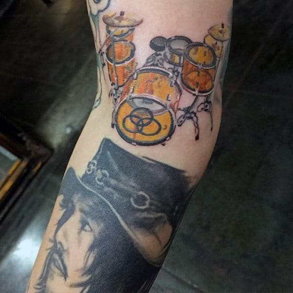 Inner Arm Guys Drum Tattoo With Watercolor Design Fill