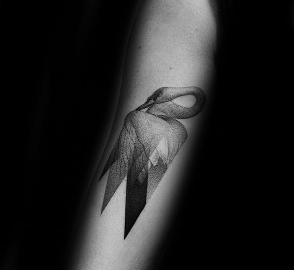 Minimalist swan tattoo with geometric wings and fine dotwork shading, blending elegance and modern design on the forearm.