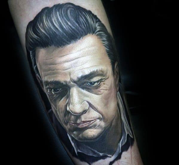 A realistic tattoo portrait of a serious-looking Johnny Cash on an arm