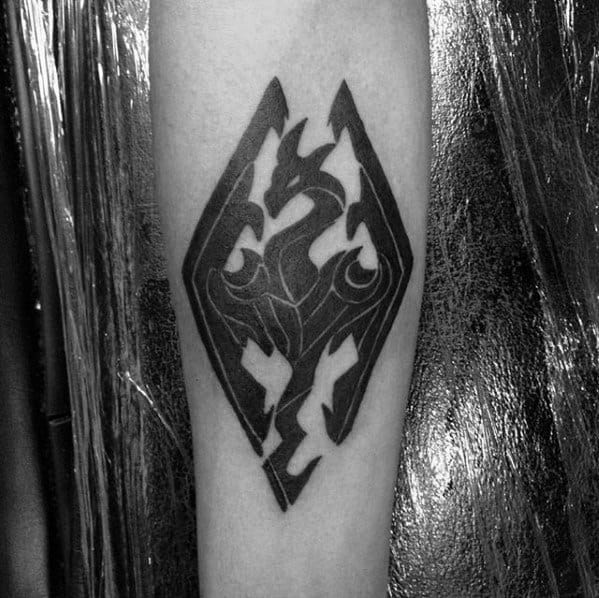Tattoo of a Skyrim-inspired dragon within a diamond shape on an arm