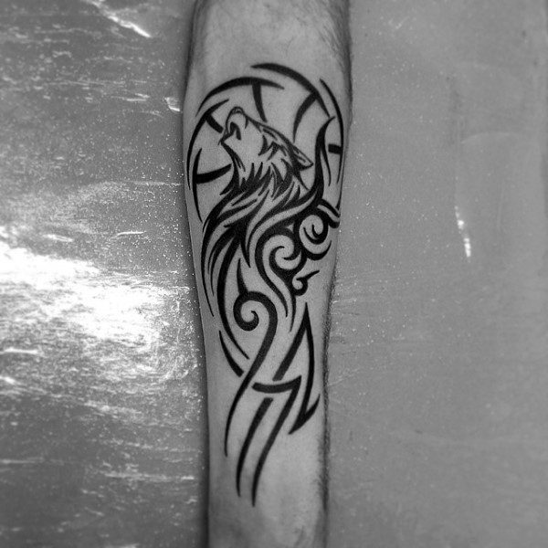 A striking black wolf tattoo graces a person's forearm, showcasing tribal artistry with swirling patterns and sharp lines