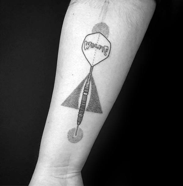 Minimalist dart tattoo with geometric dotwork elements and the word "woopie" on the flight, blending playfulness with precision.