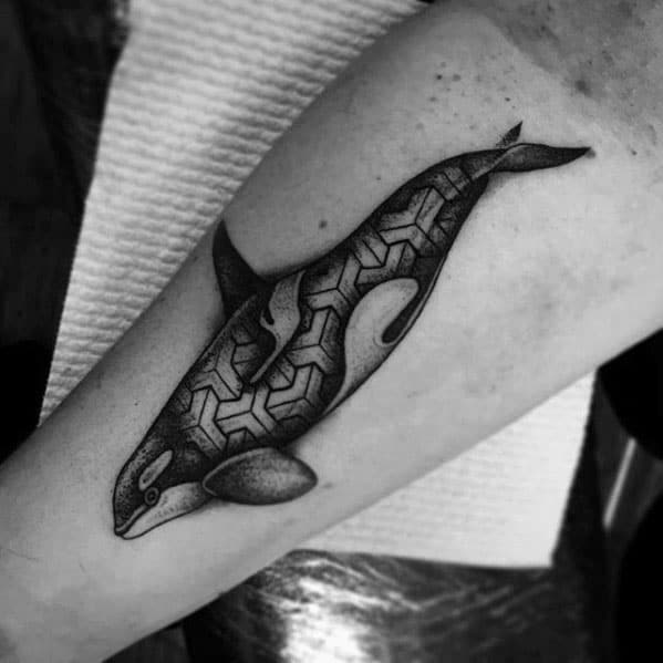 Black and gray orca tattoo on the forearm, with geometric patterns filling the whale's body for a modern and artistic design.