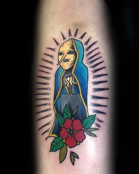 Adventure Time tattoo of the Earl of Lemongrab styled as a saint with a flower and radiating lines, placed on the upper arm.
