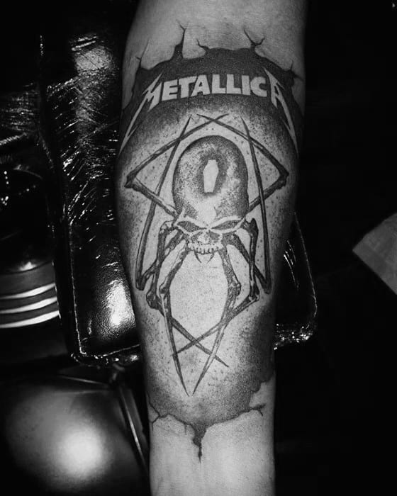 Black and grey tattoo of a spider-skulled creature inside a pentagram with the Metallica logo above, designed with a torn skin effect.