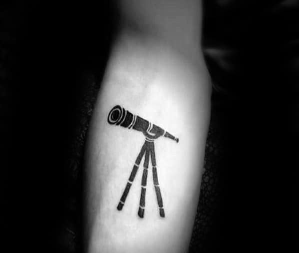 Arm tattoo of a detailed telescope, capturing stargazing wonder