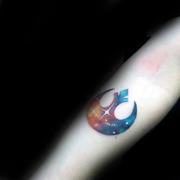 Colorful galaxy-themed Rebel Alliance tattoo on the inner forearm, featuring a vibrant cosmic design.