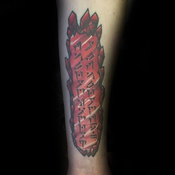 Tattoo of a Skyrim red crystal with runic symbols on forearm